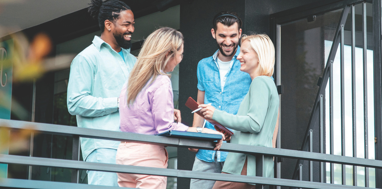 Spa colleagues discussing and smiling on an outdoor balcony