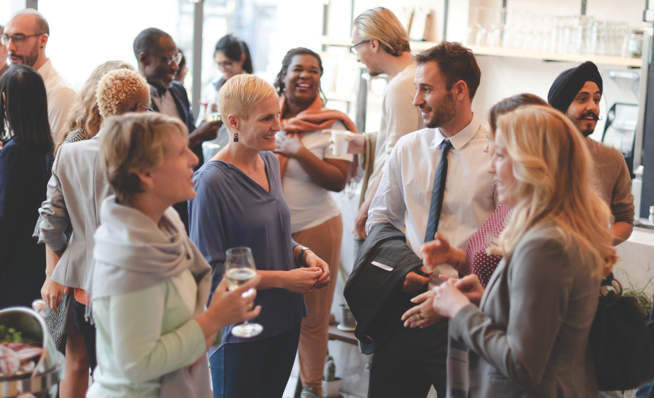 Networking event with professionals standing and holding drinks