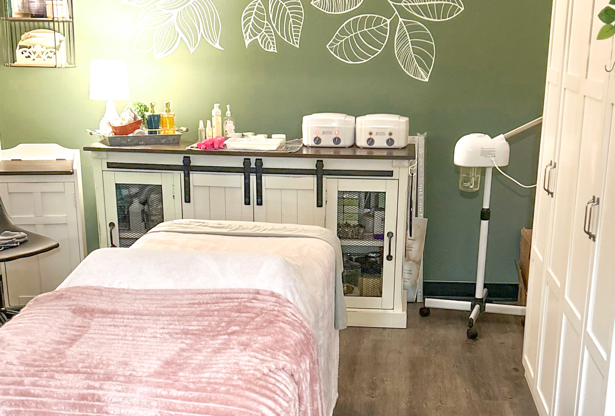 Treatment room with a bed, cabinets and skincare equipment