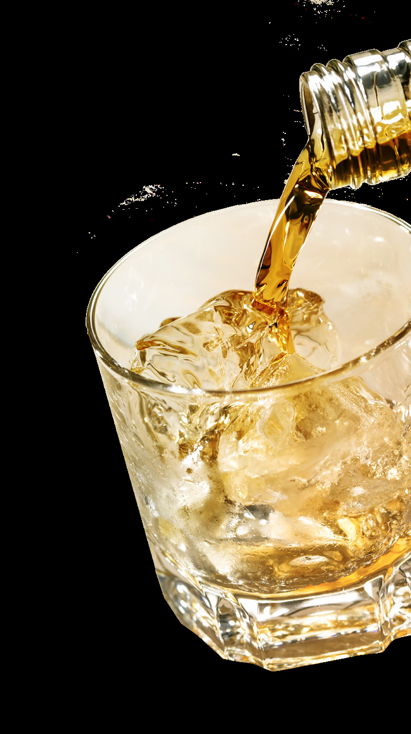 Amber bourbon liquid being poured into a crystal glass with ice