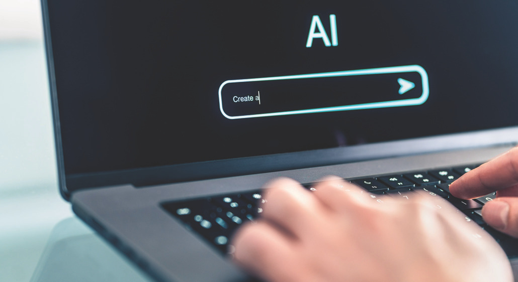 Hands typing on a laptop keyboard showing an 'AI' search field on the screen