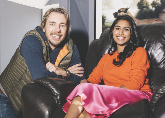 Photograph of Dax Shepard and Monica Padman sitting on a couch, smiling