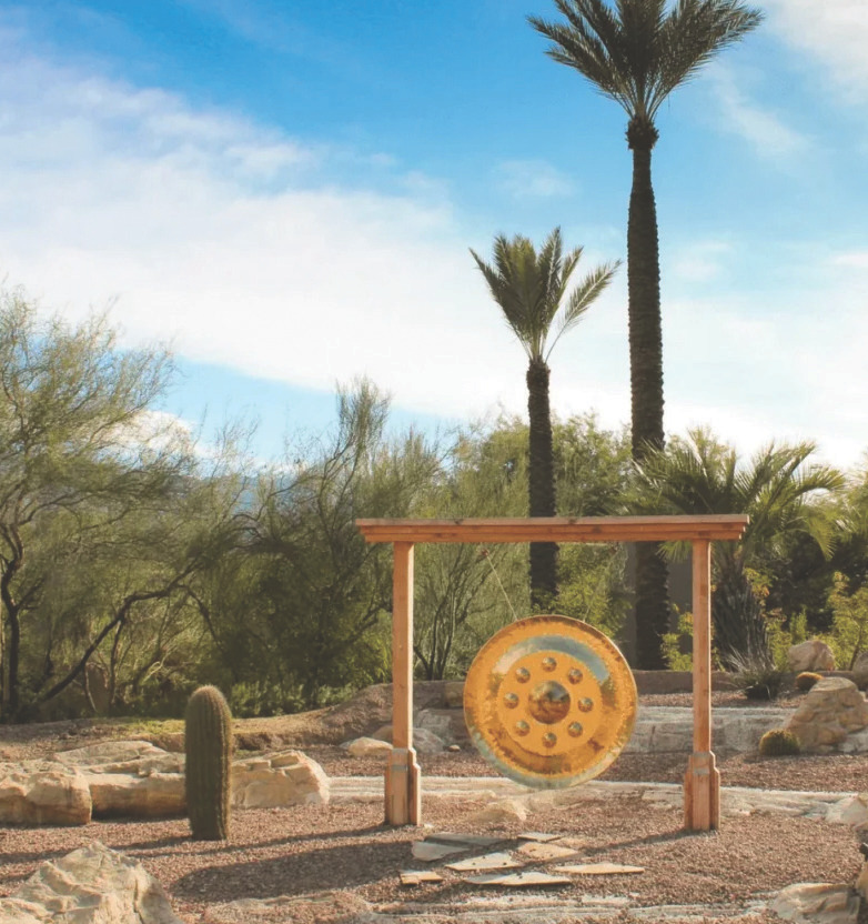 Miraval gong set in a desert landscape with palm trees