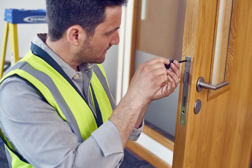 Close-up of a fire door latch being inspected for compatibility