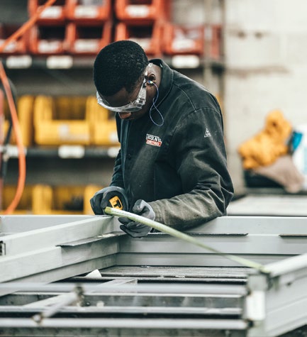 Workshop worker handling metal framing.