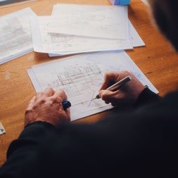 Hands reviewing architectural drawings.