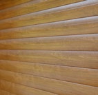 Close-up detail of a horizontal slatted woodgrain garage door finish.