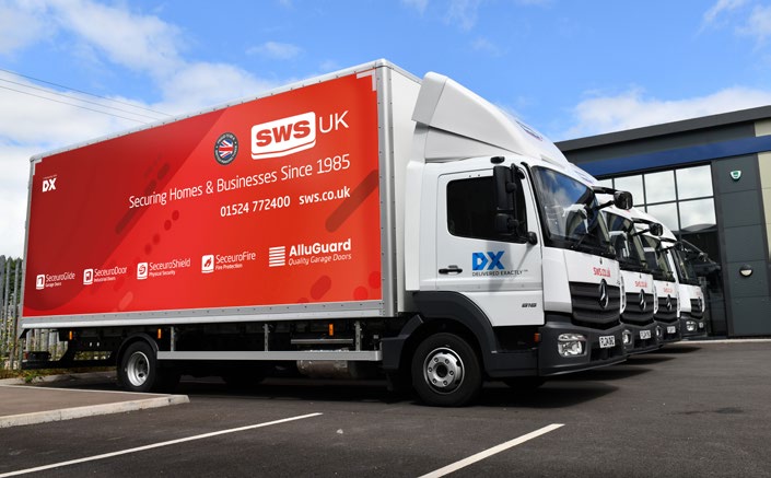 A row of branded SWS UK delivery trucks parked at a logistics depot.