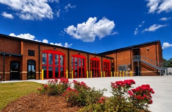 Lowndes County Fire Station exterior showing red appliance bay doors and blue sky