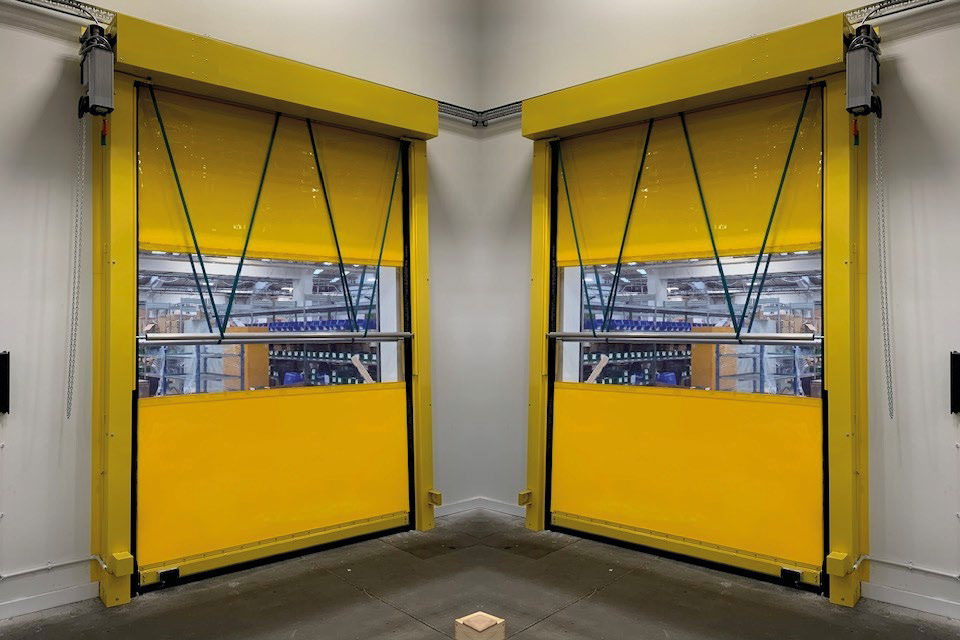 Bright yellow high-speed industrial doors in a facility (pair, partially open)