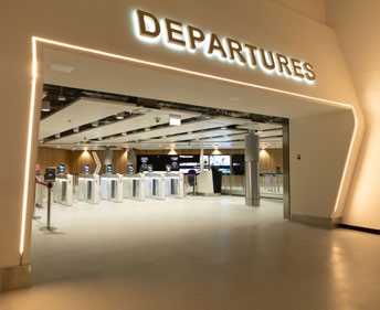 Departures area at East Midlands Airport showing automatic speed gates and open concourse.