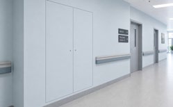 Hospital corridor with reduced-ligature doors and wall handrails