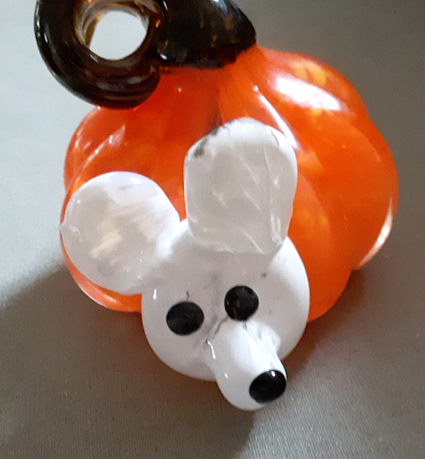 Close-up orange glass ornament shaped like a mouse
