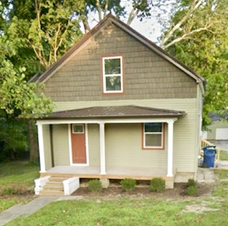 The renovated pale-green siding house with a front porch