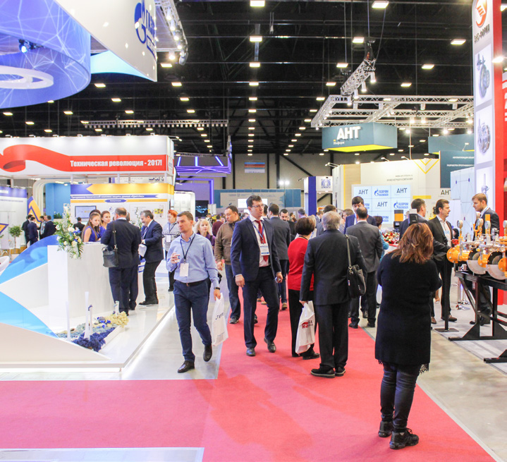 A crowded franchise expo hall with branded booths and many attendees walking through the aisles